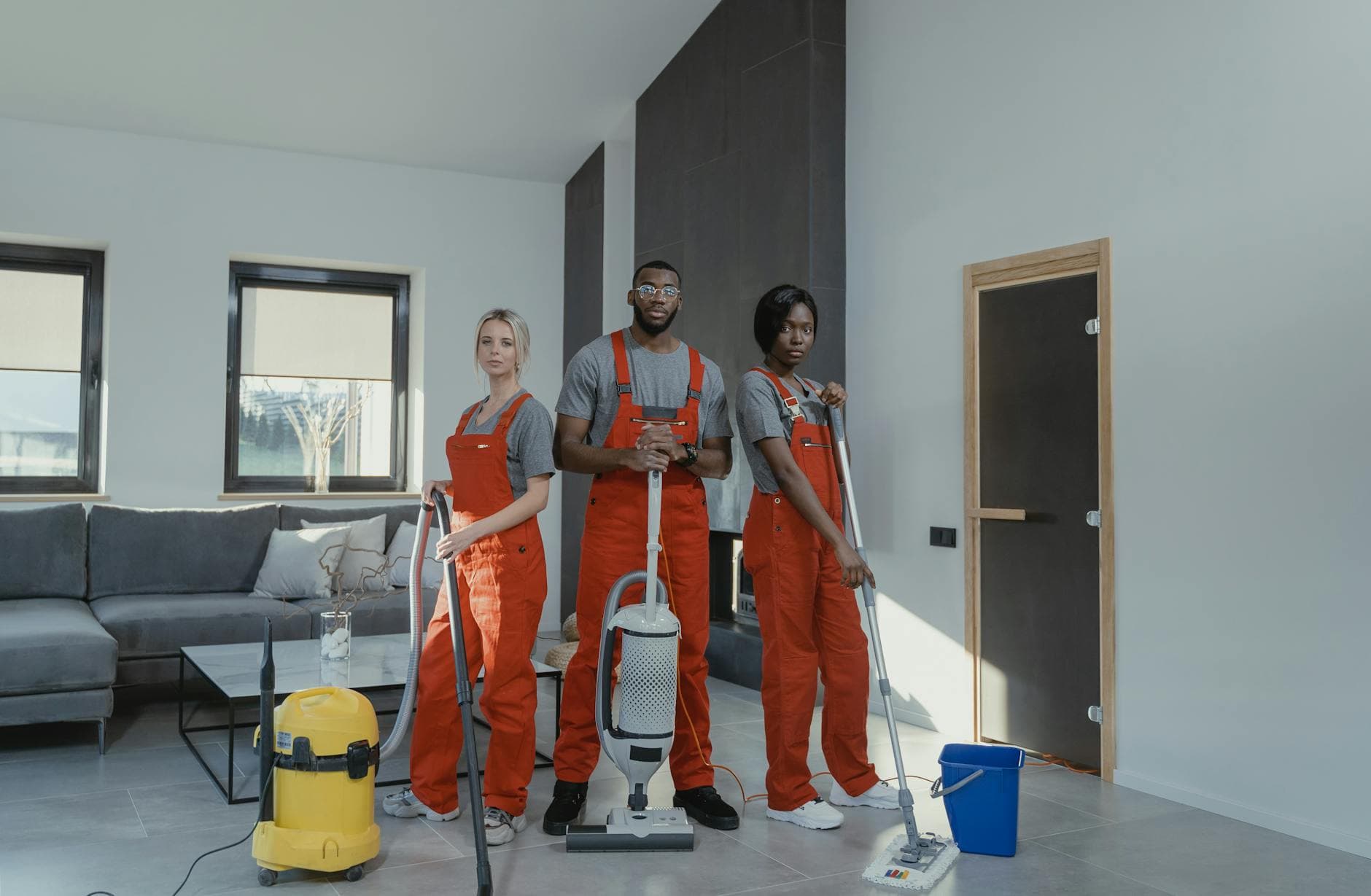 Your Business cleaning team in red uniforms ready to sanitize a modern Manhattan living room — Post-Construction Cleanup in Flushing, Queens