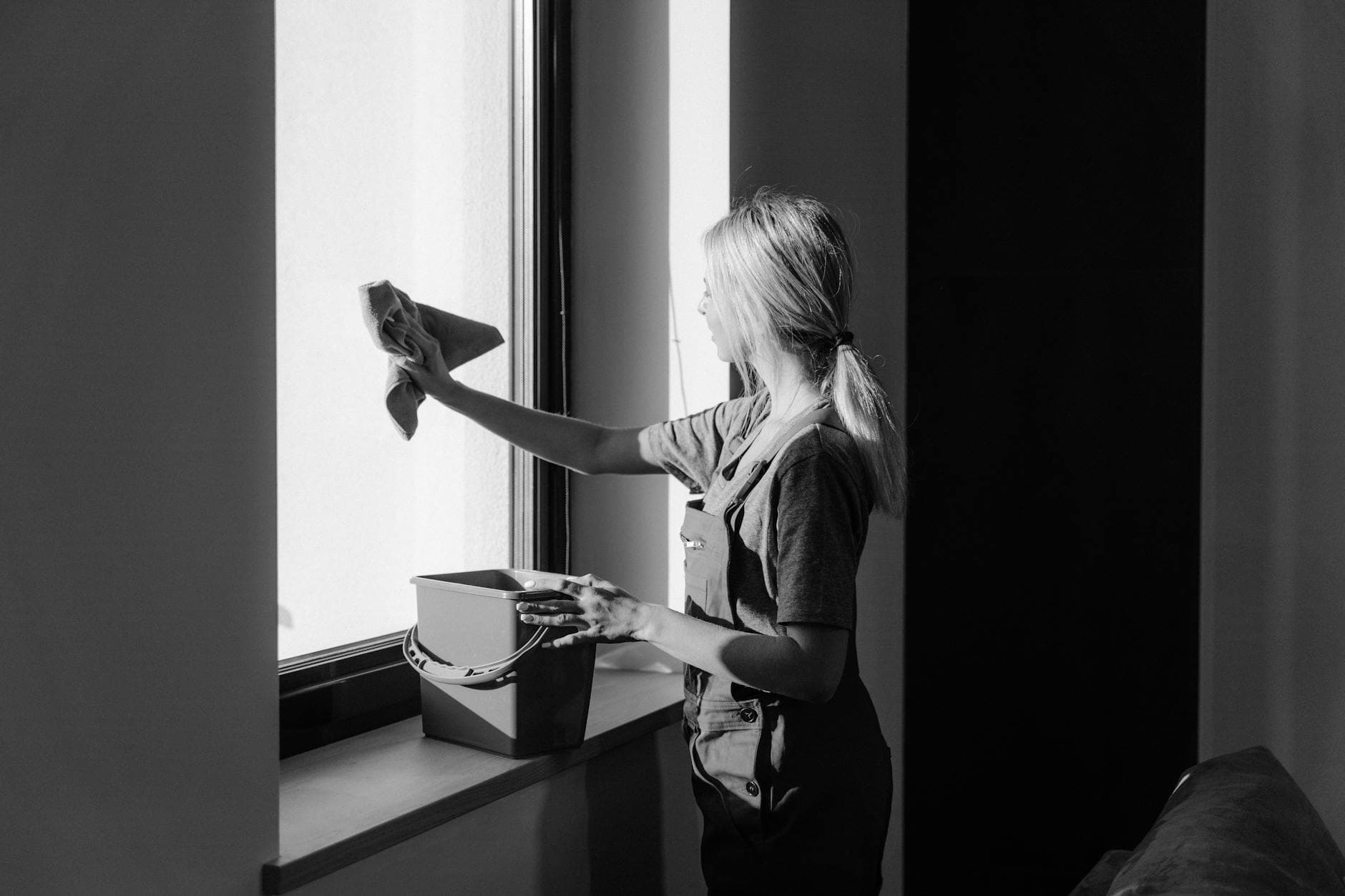Professional window cleaning in a New York City apartment using cloth and bucket — cleaning services in Chappaqua, Westchester